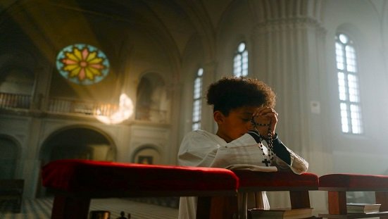 sofrimento espiritual e superacao. Uma criança orando na igreja